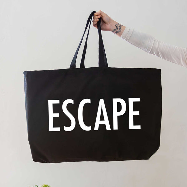 black oversized tote bag with large white escape text