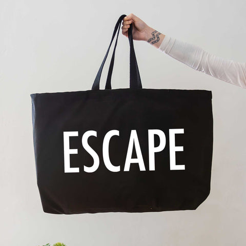 black oversized tote bag with large white escape text